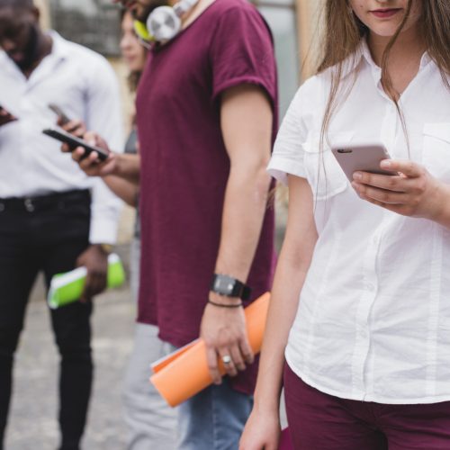 personnes-debout-tenant-des-cahiers-a-la-recherche-de-smartphones