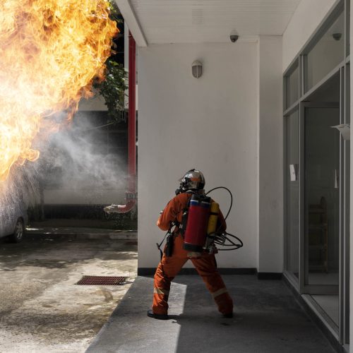 Firefighter with backpack fire extinguishing gun. Emergency Fire Rescue.