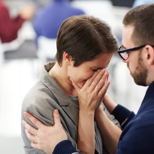 Helpful man reassuring upset woman at course of psychological support